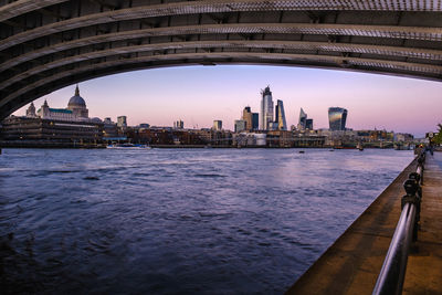 View of buildings by river with city in background