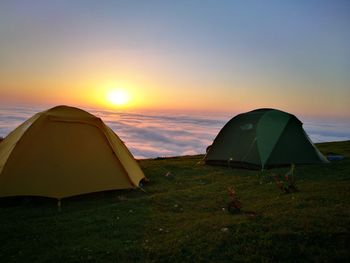 Tent on beach against sky during sunset