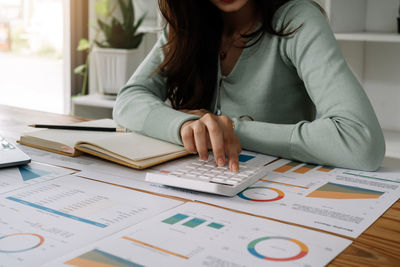 Midsection of businesswoman working on table