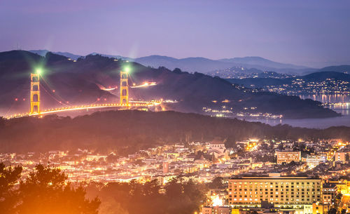 High angle view of illuminated city against sky at night