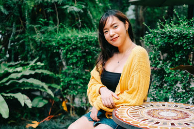 Young woman smiling while sitting outdoors