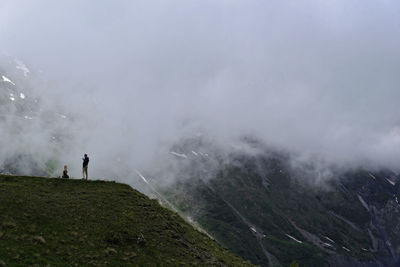 People standing on mountain against sky