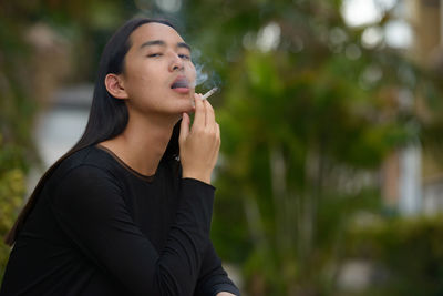 Portrait of young woman looking away outdoors