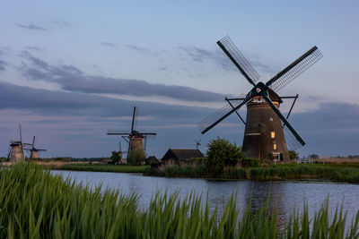 Beautiful wooden windmills at sunset in the dutch village of kinderdijk. windmills run on the wind.