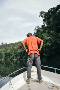 Rear view of a man standing against trees