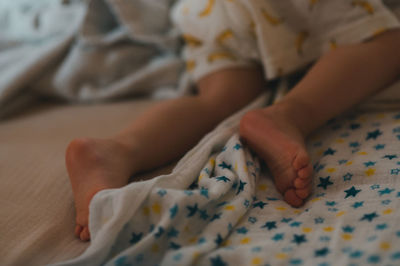 Midsection of child lying on bed