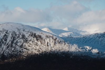 Scenic view of mountains against cloudy sky