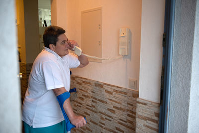 Rear view of man standing against wall