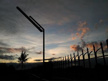 Silhouette of cranes against dramatic sky