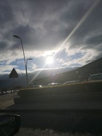 Road by street against sky during sunset