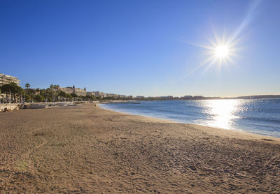 Scenic view of beach and sea against clear sky on sunny day