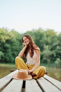 Young woman sitting on wooden table