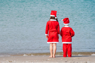 Rear view of couple standing at beach