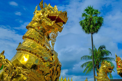 Low angle view of statue of palm tree against blue sky