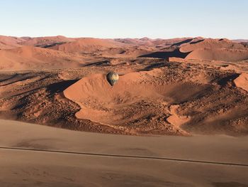 Hot air balloon over desert against sky