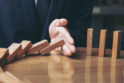 Close-up of businessman playing domino on desk