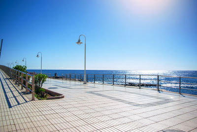 Embankment covered with paving slabs with lanterns on beach