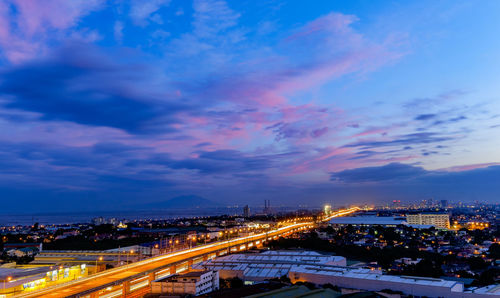 High angle view of illuminated cityscape against sky at night