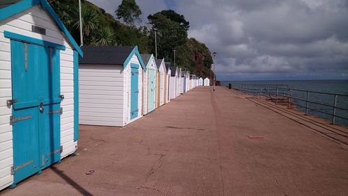 Beach hut by sea against sky