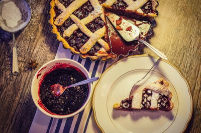 High angle view of cherry pie by sauce on table