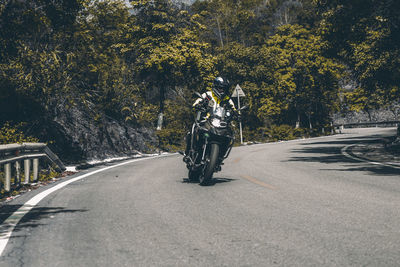 Man riding bicycle on road in city