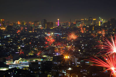 High angle view of illuminated buildings against sky at night