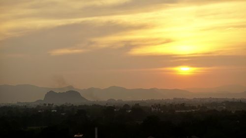 Scenic view of silhouette mountains against orange sky