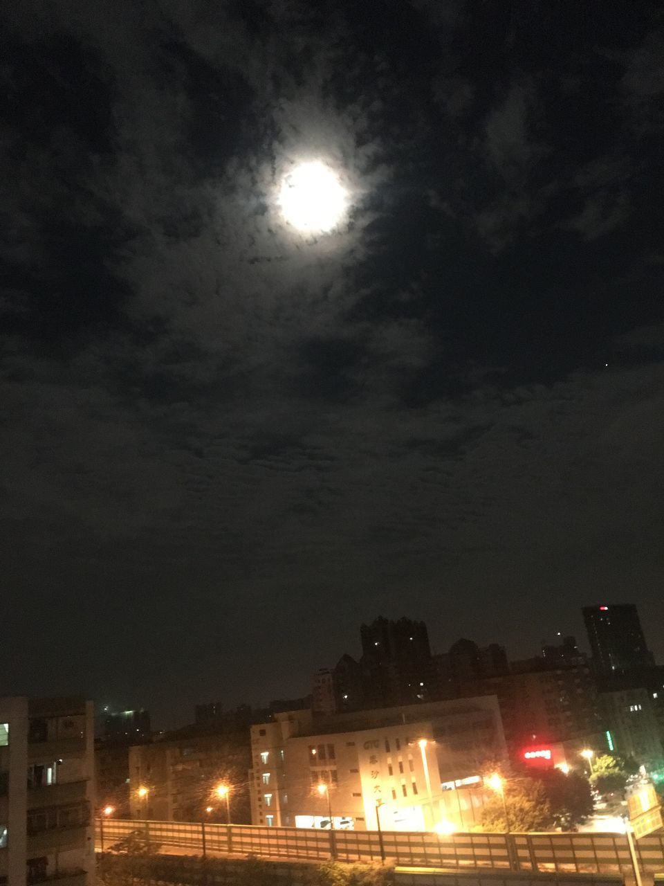 LOW ANGLE VIEW OF ILLUMINATED STREET LIGHT AGAINST BUILDINGS AT NIGHT