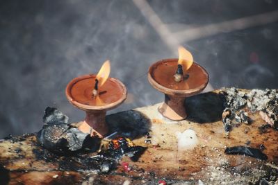 Close-up of burning candles on metal