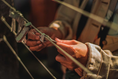 Midsection of woman tying prayer text on string