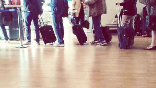 Low section of people standing on tiled floor
