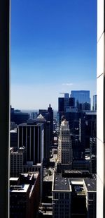 Modern buildings in city against clear blue sky