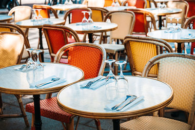 Empty chairs and tables at sidewalk cafe