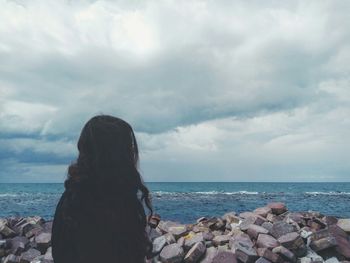 Rear view of woman by sea against sky