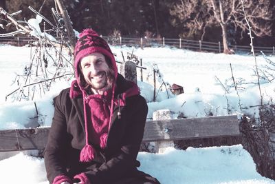 Portrait of smiling young woman sitting on snow