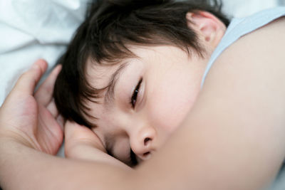 Close-up portrait of cute baby girl on bed