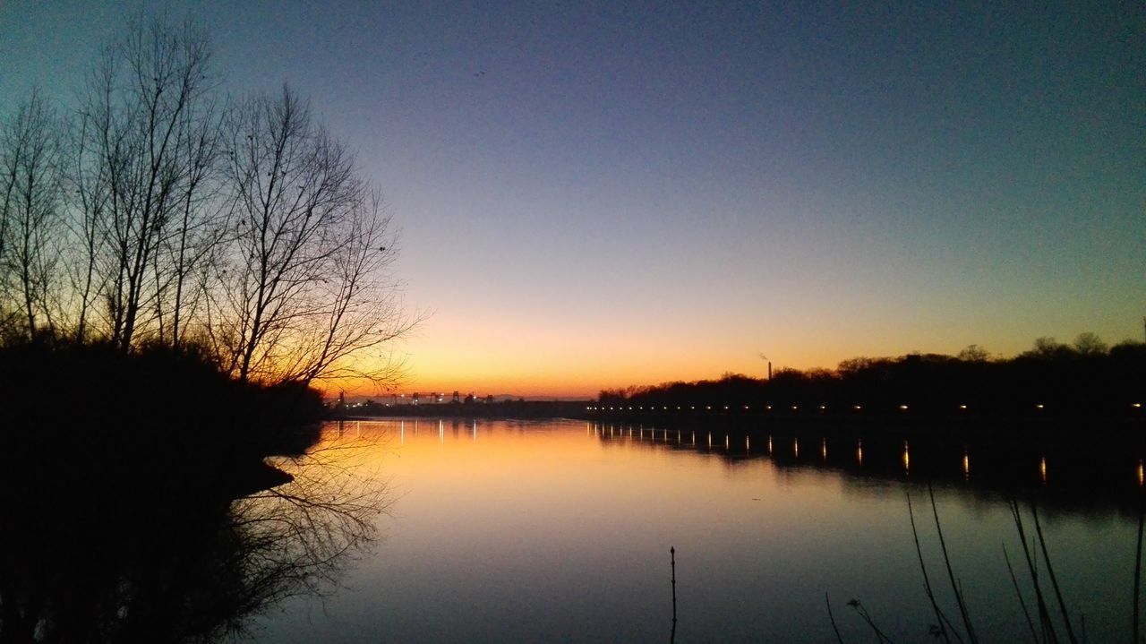 SILHOUETTE TREES BY LAKE AGAINST SKY AT SUNSET