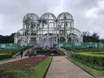 Ferris wheel by building against sky