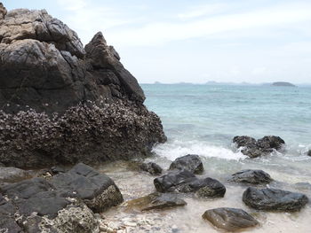 Scenic view of rocks in sea against sky