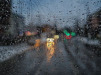 Raindrops on glass window during rainy season. urban traffic view