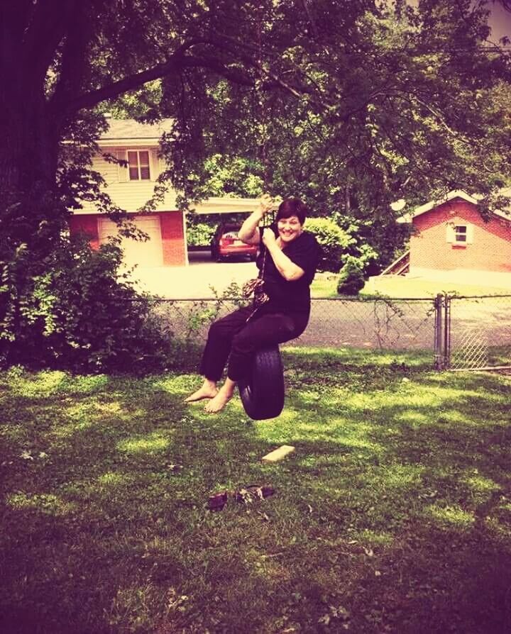 SIDE VIEW OF A SMILING YOUNG WOMAN JUMPING