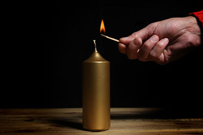Close-up of hand holding candles on table