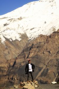 Man standing on rock against mountains