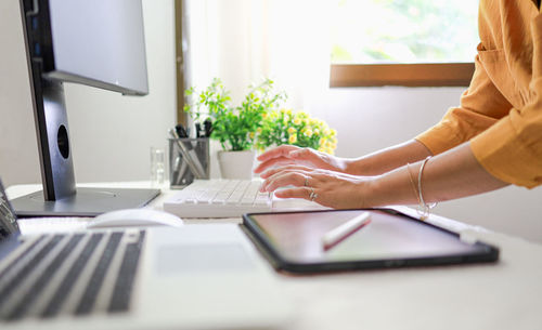 Midsection of man using laptop on table