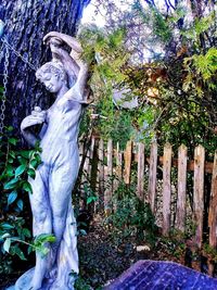 Statue amidst trees on field