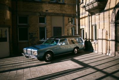 Car on street by buildings in city