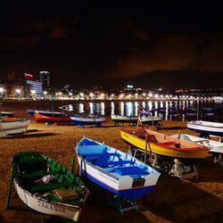 Boats moored in harbor at night