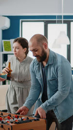 Business colleagues playing foosball at office