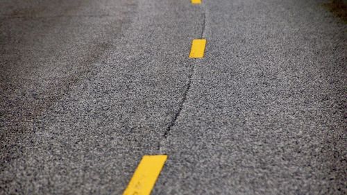 Close-up of yellow arrow symbol on road