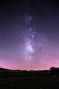 Scenic view of silhouette field against sky at night